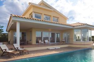 a villa with a swimming pool and a house at Casa Bárbara in Es Castell