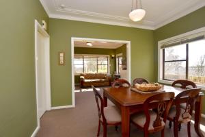 a dining room with green walls and a table and chairs at Raspberry Terrace of Leura in Leura