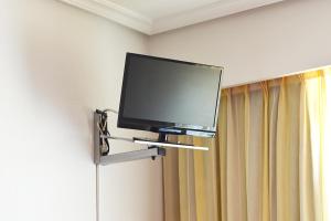 a flat screen tv on a wall in a room at Hotel Os Caracoles in Pereiro de Aguiar