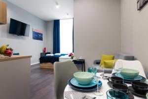 a dining room with a table with plates and glasses at Kings City - Sławkowska Apartments in Krakow