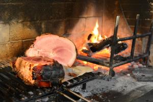 a piece of meat is being cooked in an oven at Affittacamere B&B Trattoria della Posta in Maissana