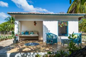 - une terrasse avec un lit et deux chaises bleues dans l'établissement Refugios Parajuru - Casa Manga, à Parajuru