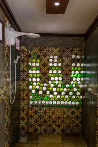 a shower with a wall of different colored bottles at Refugios Parajuru - Casa Manga in Parajuru +45 photos