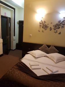 1 cama en una habitación con una luz en la pared en Casa Teilor, en Piteşti