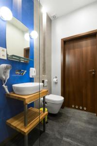 a bathroom with a sink and a toilet and a mirror at Kings City - Sławkowska Apartments in Krakow