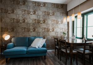 een woonkamer met een blauwe bank en een tafel bij Hotel Mathildedal in Matildedal