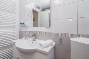 a white bathroom with a sink and a mirror at Charming Apartment in Koper +16 photos