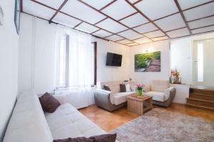 a living room with a white couch and chairs at Charming Apartment in Koper