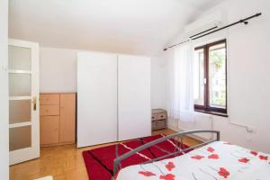 a bedroom with a bed and a red rug at Charming Apartment in Koper
