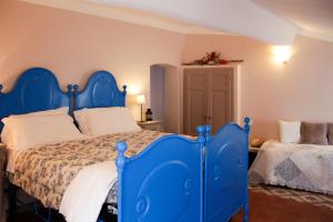 a bedroom with a blue bed with white sheets at La Locanda Del Podestà Cinque terre in La Spezia