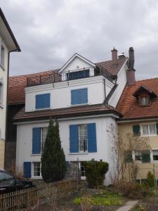 Una casa blanca con persianas azules. en Haus Gaschür, en Bad Ragaz