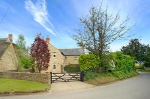 a house with a gate in front of a yard at Brook Farm Cottage in Brackley
