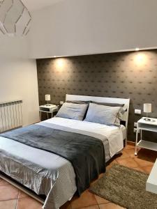 sypialnia z dużym łóżkiem i dwoma stołami w obiekcie Etna Holidays Home SereLeo w mieście Santa Venerina