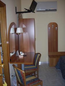 Camera dotata di scrivania con sedia e lampada. di Ristorante Albergo Roma ad Arma di Taggia