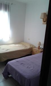 1 dormitorio con 2 camas y ventana en Apartamentos Mediterranean View en Llançà