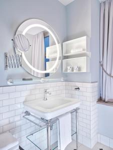 Baño blanco con lavabo y espejo en Hapimag Ferienwohnungen Hamburg, en Hamburgo