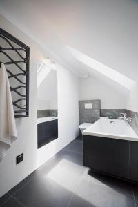 a white bathroom with a tub and a sink at Ostoja in Rzyki