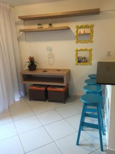 Habitación con mesa y taburete azul en Flat no La Piazzetta - Ap. 14 Térreo, en Pipa