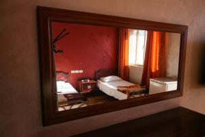 a mirror reflecting a red room with two beds at Sun Rise Hotel & Hostel & Tours in Amman