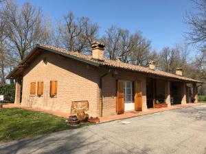 a small brick house with brown doors and windows at Mb bed & breakfast in Zola Predosa