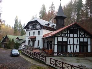 un grand bâtiment blanc avec une tour d'horloge. dans l'établissement Hotel Stavilar, à Sinaia