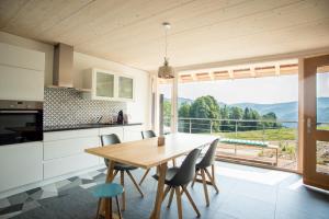 a kitchen and dining room with a table and a large window at La Joux Chaupe in Saint-Ursanne