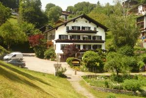 ein Haus auf einem Hügel mit einem Auto vor dem Haus in der Unterkunft Pension Stüttler in Schruns-Tschagguns