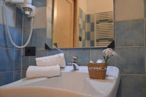 a bathroom with a sink with a basket of towels at Affittacamere Porticciolo in Castelnuovo del Garda