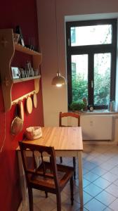 a kitchen with a wooden table and a window at Bastians Herberge in Leipzig