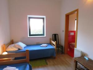 een kleine slaapkamer met een blauw bed en een raam bij Apartments Dolić Novalja in Novalja