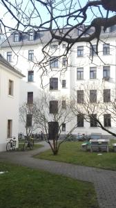 a large white building with bikes parked in front of it at Bastians Herberge in Leipzig