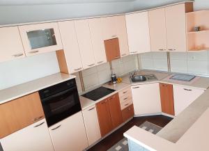 una cucina con armadi bianchi e un apparecchio nero di Luxe Apartment a Ohrid