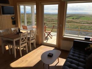 ein Wohnzimmer mit einem Sofa und einem Tisch sowie einem Balkon in der Unterkunft Sodulsholt Cottages in Sodulsholt + 33 Fotos