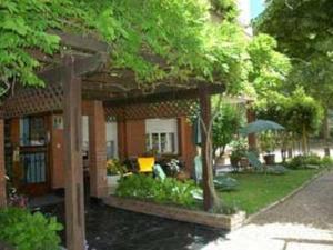 una casa con un laghetto davanti di Hotel La Golondrina a Pinamar Altre 10 foto