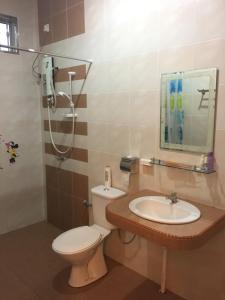 een badkamer met een toilet, een wastafel en een douche bij Big Garden Homestay in Pantai Remis