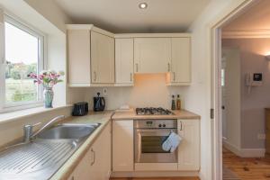 a kitchen with white cabinets and a sink at The Nook County Dublin in Dublin