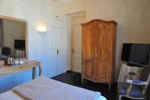 a bedroom with a wooden cabinet and a television at Villa Valflor chambres d'hôtes et appartements in Marseille
