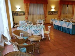 a restaurant with blue and white tables and chairs at Hotel Belmare in Porto Azzurro