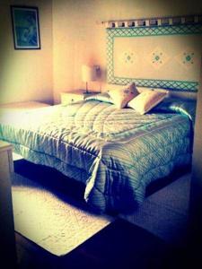 ein Schlafzimmer mit einem großen Bett mit zwei Kissen darauf in der Unterkunft Domus Maria in Milis