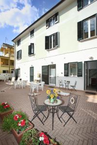 a patio with a table and chairs and a building at B&B Central Toma in Montecatini Terme