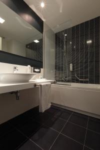 a bathroom with a sink and a shower and a mirror at Holiday Inn Milan Nord Zara by IHG in Cinisello Balsamo