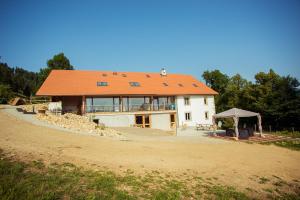 a house with an orange roof on a dirt road at La Joux Chaupe in Saint-Ursanne
