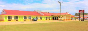 un bâtiment jaune et rouge avec un toit rouge dans l'établissement Travel Inn Eutaw, à Eutaw