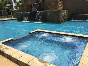 uma grande piscina com uma cascata num edifício em Studio Homestay SGarden Resort Residences em Kuantan