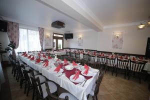 a banquet hall with tables and chairs with red napkins at Guesthouse Magic in Băile Herculane