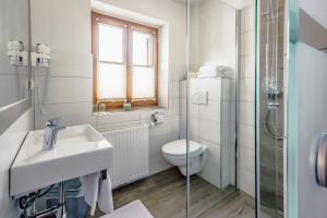 a white bathroom with a sink and a toilet at Pension Tannhof in Fuschl am See