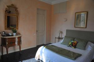 a bedroom with a bed and a table and a mirror at Villa Valflor chambres d'hôtes et appartements in Marseille