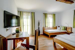 sala de estar con cama y sofá en Pension Tannhof en Fuschl am See