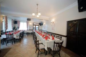 a large dining room with tables and chairs with red napkins at Guesthouse Magic in Băile Herculane