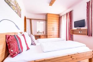 pokój hotelowy z dwoma łóżkami i telewizorem w obiekcie Pension Tannhof w mieście Fuschl am See